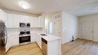 Located at 5171 Bowman Rd in Macon, GA, this single-story, 2-bedroom, 1-bathroom home offers a clean, modern design with light wood flooring flowing consistently throughout the living spaces. The open-concept kitchen and living room serve as the heart of the home, featuring crisp white shaker-style cabinetry, a peninsula with a built-in sink, white quartz countertops, and a full suite of stainless steel appliances including a refrigerator, range, microwave, and dishwasher. A pendant light fixture and ceiling fan add functional style to this combined space. The bedrooms are bright and comfortable, each equipped with ceiling fans and natural light from windows with blinds. The primary bedroom offers a generous footprint with access to a walk-in closet featuring wire shelving. An additional closet provides further storage throughout the home. A hallway connects the bedrooms to the shared bathroom, laundry area, and utility room. The attached garage is spacious, with a concrete floor, automatic opener, and interior access door — ideal for secure parking or additional storage. Throughout the home, neutral white walls and warm wood-tone flooring create a bright, cohesive, and move-in-ready atmosphere.