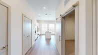 Located at 1602 Belt Line Rd in Garland, TX, this single-story, one-bedroom, one-bathroom unit offers a thoughtfully designed layout with modern finishes throughout. The open-concept living and kitchen area is anchored by a central island topped with granite countertops and an undermount sink, providing both functionality and visual appeal. The kitchen is equipped with stainless steel appliances, including a side-by-side refrigerator with ice maker, an electric range, and a built-in microwave, all complemented by crisp white cabinetry that extends to the ceiling for ample storage. A large window allows natural light to pour in, brightening the space. Warm wood-look plank flooring runs throughout the main living areas, adding a cohesive and contemporary feel. The living area features a ceiling fan with a brushed gold finish and a stylish barn door that adds a modern accent. The bedroom is carpeted for comfort, fitted with its own ceiling fan, and connects to a closet area. The bathroom is clean and well-appointed, featuring a soaking tub with a tiled surround in a neutral marble-like pattern and brushed nickel fixtures, creating a calm and polished retreat.