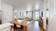 This single-story residence offers a thoughtfully designed layout across two bedrooms and two bathrooms. The open-concept living and dining area serves as the heart of the home, featuring warm wood-look flooring, neutral walls, and a ceiling fan that enhances the bright, airy atmosphere. Large windows and a glass-panel exterior door flood the space with natural light while providing outdoor views, and the dining area accommodates a full-sized table, making it well-suited for entertaining.

The kitchen is finished with white shaker-style upper cabinetry, light lower cabinets, and crisp white countertops. Stainless steel appliances — including a refrigerator with ice maker, range, microwave, and dishwasher — are complemented by a peninsula with barstool seating and a window above the sink.

Both bedrooms feature distinctive blue accent walls, plantation shutters with sheer curtain overlays, ceiling fans, and wood-look flooring. The primary bedroom includes an en-suite bathroom with a walk-in glass shower and an organized walk-in closet. A stacked washer and dryer unit is conveniently integrated within the second bathroom area, adding practical functionality to the overall layout.
