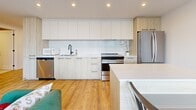 Located at 3440 Boul Saint-Elzéar O in Laval, this well-appointed one-bedroom, one-bathroom unit offers a thoughtfully designed layout with a contemporary aesthetic. Warm hardwood flooring flows throughout the space, complemented by exposed concrete ceilings that lend an industrial character to the modern interior.

The kitchen is a standout feature, finished with two-tone cabinetry in light wood and white, a geometric hexagonal tile backsplash, white quartz countertops, and a full suite of stainless steel appliances including a French door refrigerator, electric range, dishwasher, and built-in microwave. A central island provides additional prep and dining space, making the kitchen both functional and stylish.

The bedroom is a comfortable retreat, featuring large floor-to-ceiling windows that frame open city views and invite generous natural light. A built-in sliding closet and exposed concrete ceiling complete the room's modern-industrial character.

The bathroom is finished in an all-white palette with large-format floor tiles, a soaker tub with a sliding glass enclosure, a rain showerhead, and matte black fixtures and hardware that add a refined contrast. A floating vanity with mirror completes the clean, spa-like finish.

This unit combines modern finishes with functional design, making it an ideal space in the heart of Laval.