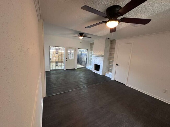 Amplia sala de estar y comedor de concepto abierto con modernos ventiladores de techo y pisos laminados. - 7700 Creekbend Dr