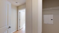 This single-floor residence offers a cohesive and functional layout with consistent finishes throughout. The kitchen serves as a central highlight, featuring a peninsula with dark granite countertops, an undermount sink, and light maple cabinetry extending to the ceiling for ample storage. Stainless steel appliances, including a refrigerator, range, and built-in microwave, are complemented by a herringbone-patterned tile backsplash. A circular flush-mount light fixture illuminates the space.

Light hardwood-style flooring flows throughout the main living areas and into the bedrooms, creating visual continuity. One bedroom features a window with horizontal blinds allowing natural light, while another room benefits from a skylight panel overhead. A dedicated closet area with built-in shelving provides organized storage.

The hallway connects rooms with a clean, neutral palette of warm beige tones and white trim. The full bathroom features dark tile flooring, a tub-shower combination with tiled surround, a maple vanity with granite countertop, an undermount sink, and a large mirror with a multi-bulb light fixture above. The overall design is practical and uniform, with a calm, neutral aesthetic throughout.