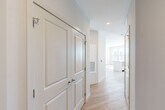 Located at 2119 Post Rd in Warwick, Rhode Island, this single-floor 2-bedroom, 2-bathroom residence offers a well-designed layout with modern finishes throughout. The open-concept living, dining, and kitchen area serves as the heart of the home, featuring light wood-style flooring and a bank of large windows that flood the space with natural light and offer views of the surrounding area. The kitchen is equipped with white cabinetry, a center island with a clean white countertop, and stainless steel appliances. A central hallway connects the main living areas to the private quarters, lined with panel-style doors and ample closet storage — five closets in total. Both bedrooms are carpeted and well-lit, with large windows providing outdoor views. The primary bedroom features generous proportions and dual closets for excellent storage. The two bathrooms are finished with white subway tile, blue-gray vanities, and chrome fixtures; one includes a walk-in glass-enclosed shower, while the other offers a full tub-shower combination. Additional conveniences include an in-unit laundry area and a utility room, rounding out a thoughtfully functional floor plan.