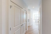 Located at 2119 Post Rd in Warwick, Rhode Island, this single-floor 2-bedroom, 2-bathroom residence offers a well-designed layout with modern finishes throughout. The open-concept living, dining, and kitchen area serves as the heart of the home, featuring light wood-style flooring and a bank of large windows that flood the space with natural light and offer views of the surrounding area. The kitchen is equipped with white cabinetry, a center island with a clean white countertop, and stainless steel appliances. A central hallway connects the main living areas to the private quarters, lined with panel-style doors and ample closet storage — five closets in total. Both bedrooms are carpeted and well-lit, with large windows providing outdoor views. The primary bedroom features generous proportions and dual closets for excellent storage. The two bathrooms are finished with white subway tile, blue-gray vanities, and chrome fixtures; one includes a walk-in glass-enclosed shower, while the other offers a full tub-shower combination. Additional conveniences include an in-unit laundry area and a utility room, rounding out a thoughtfully functional floor plan.
