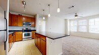 This single-floor residence offers a thoughtfully designed layout that seamlessly connects the kitchen, dining, and living areas. The kitchen serves as a central hub, featuring warm honey-toned cabinetry, dark granite countertops, and a full suite of stainless steel appliances including an electric range, built-in microwave, and dishwasher. Light tile flooring runs throughout the kitchen, and a peninsula with pendant lighting overhead provides additional workspace while opening toward the carpeted living area. The living space benefits from natural light through blinds-fitted windows and is equipped with a ceiling fan.

The bedrooms are carpeted and generously proportioned, each with windows allowing natural light and ceiling fans for comfort. The primary bathroom features tile flooring, a granite-topped vanity with rich wood cabinetry, built-in shelving, and direct access to a walk-in closet. A secondary bathroom similarly offers tile flooring and wood cabinetry. A dedicated utility area houses in-unit washer and dryer hookups alongside a water heater. Throughout, neutral tones and consistent finishes create a cohesive, functional living environment.