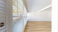 Located at 390 N Madison Ave in Pasadena, CA, this one-bedroom, one-bathroom unit offers a well-designed layout spread across a single floor. Light-toned hardwood flooring flows consistently throughout, creating a clean, cohesive aesthetic in every room.

The living areas are bright and airy, featuring a bank of large windows that frame views of the tree-lined neighborhood and provide an abundance of natural light. A wall-mounted fireplace adds a functional focal point to the main living space, while access to a private balcony enhances the sense of openness.

The kitchen is efficiently laid out with white cabinetry, granite countertops, stainless steel appliances including a refrigerator and range, and an under-mount sink — offering a practical and attractive cooking space.

The bedroom is a cozy, well-proportioned retreat with high-placed windows that allow natural light while maintaining privacy. Mirrored sliding closet doors add depth to the room and offer convenient built-in storage. The bathroom features classic black-and-white mosaic tile flooring, a combined tub and shower, and a granite-topped vanity, lending a timeless character to the space.

Throughout the unit, crisp white walls and textured ceilings contribute to a bright, clean ambiance well-suited to comfortable everyday living in the heart of Pasadena.