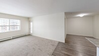 Located at 5000 Clover Bar Rd in Sherwood Park, Alberta, this 2-bedroom, 1-bathroom unit offers a practical and comfortable single-floor layout. The open-concept kitchen and dining area serves as the heart of the home, featuring white cabinetry, granite-style countertops, a peninsula with a double stainless steel sink, track lighting, and black appliances including a refrigerator, electric range, and built-in microwave. Durable wood-look vinyl flooring runs throughout the kitchen and main living areas, while plush carpet adds warmth to the living room and bedrooms. The living room is generously proportioned, bright with natural light from large windows, and features baseboard heating. Both bedrooms are well-sized, carpeted, and include baseboard heaters and windows with exterior views; the primary bedroom offers ample closet space. The full bathroom is finished with wood-look vinyl flooring, a granite-style vanity with white cabinetry, and a full tub-shower combination. A dedicated laundry room with side-by-side washer and dryer units, built-in wire shelving, and additional storage rounds out the unit. Multiple closets throughout provide generous storage solutions for everyday living.