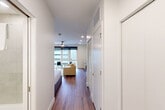Located at 945 Mid City Dr in Huntsville, Alabama, this efficiently designed studio offers a thoughtful single-floor layout that maximizes every square foot. Rich hardwood-style flooring runs throughout the main living area, connecting the open living space to the well-appointed kitchen and private sleeping area. A ceiling fan overhead and large floor-to-ceiling windows flood the living space with natural light and offer views of the surrounding area, creating an airy, welcoming ambiance.

The kitchen is a standout feature, outfitted with light wood cabinetry, open industrial-style shelving, a tile backsplash, stainless steel appliances including a full-size refrigerator and electric range, and a sleek undermount sink with a matte black faucet — providing full functionality in a compact footprint.

The sleeping area is bright and neatly proportioned, with clean white walls, a ceiling fan, and warm lighting that contributes to a calm, restful atmosphere. The bathroom is finished in crisp white large-format tile, complete with a glass-enclosed walk-in shower and a wood-accented vanity for a modern, clean aesthetic. A dedicated closet and in-unit laundry add practical convenience. The overall design reflects a contemporary, minimalist style well-suited for efficient urban living.