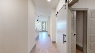 Located at 5400 Haltom Rd in Haltom City, TX, this thoughtfully designed 2-bedroom, 2-bathroom residence offers a clean, modern aesthetic across a single level. Light wood-tone flooring flows throughout the main living areas, complemented by crisp white walls and an abundance of natural light from well-placed windows.

The open-concept kitchen and living area serves as the heart of the home. The kitchen is equipped with stainless steel appliances, including a refrigerator, range, and dishwasher, alongside white shaker-style cabinetry and a granite-topped island with a deep single-basin sink and matte black fixtures. Pendant lighting adds a stylish, contemporary touch above the island.

A striking sliding barn door with matte black hardware connects spaces and adds a modern farmhouse character to the interior. The living area benefits from natural light and an open connection to the kitchen.

The primary bedroom is a comfortable, well-proportioned retreat featuring plush carpeting, a ceiling fan, and a window with outdoor views. The second bedroom is equally bright and functional.

Both bathrooms are finished with granite countertops and matte black fixtures. One features a tub-shower combination with large-format tile surround, while the other offers clean, minimal finishes. A dedicated closet provides additional storage. The overall ambiance is bright, clean, and move-in ready.