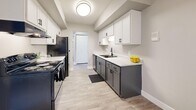 Located at 7352 S Dewmar Ct in Midvale, Utah, this one-bedroom, one-bathroom unit offers a well-designed single-floor layout with thoughtfully updated finishes throughout. The combined kitchen and living area forms the heart of the home, with light gray luxury vinyl plank flooring extending through the main living spaces, complemented by neutral-toned walls and crisp white baseboards. The living room features a sliding glass door with vertical blinds, allowing natural light to fill the space and providing access to an outdoor area. The kitchen is a standout feature, showcasing a two-tone design with white upper cabinetry and charcoal lower cabinets, light stone countertops, a stainless steel sink, and black appliances including a range and refrigerator. A flush ceiling light adds a clean, modern touch. The bedroom offers a comfortable, cozy atmosphere with plush carpet flooring, a natural window view, a textured ceiling, and a full-width double bifold closet providing generous storage. The bathroom is well-appointed with a white vanity, light stone countertop, a tub-shower combination with tile surround, and warm wood-look flooring. A connecting hallway ties the layout together efficiently, making this a practical and attractive unit.