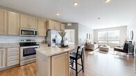 Located at 1331 Crossings Blvd in Shakopee, MN, this well-appointed two-bedroom, two-bathroom residence offers a thoughtfully designed single-floor layout. The open-concept kitchen is a standout feature, showcasing light maple cabinetry, granite countertops, a subway tile backsplash, stainless steel appliances, and a central island with bar seating — all flowing seamlessly into the living room. The living room is bright and inviting, benefiting from large windows that fill the space with natural light and warm wood-style flooring underfoot. Both bedrooms are carpeted and feature windows with outdoor views, providing a calm and restful atmosphere. The spacious primary bedroom includes a walk-in closet outfitted with wire shelving for ample storage. The two bathrooms are finished with granite-topped vanities and wood-style flooring, maintaining a consistent, clean aesthetic. A dedicated in-unit laundry room houses a full-size washer and dryer with additional wire shelving above. The residence also includes a private balcony, offering outdoor access. Neutral tones, quality finishes, and functional design define this comfortable and practical home.