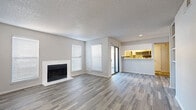 Located in Phoenix, AZ, this single-story, 2-bedroom, 2-bathroom residence offers a well-organized and efficiently designed layout. The open-concept living and dining area is anchored by a clean, white-surround fireplace and flanked by multiple windows with blinds, allowing natural light to fill the space. Wood-look plank flooring and a textured ceiling run throughout, giving the home a cohesive, contemporary feel. A sliding glass door connects the living area to an outdoor space. The kitchen features a pass-through counter with bar seating, light cabinetry, a stainless steel refrigerator, and a tile backsplash, keeping it both functional and bright. The primary bedroom offers a comfortable footprint with a ceiling fan and dedicated closet. The second bedroom is bright and well-proportioned, with large windows and tile-look flooring. Both bathrooms are fitted with tub-shower combos and clean white fixtures. Additional features include built-in shelving in one of the bedrooms, two hallways for smooth navigation throughout, and two closets for ample storage. The neutral color palette and updated finishes throughout contribute to a clean, move-in ready ambiance.