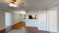 Located at 11655 Briar Forest Dr in Houston, Texas, this single-floor residence offers a well-organized layout designed for comfortable everyday living. The living room serves as the heart of the unit, featuring rich hardwood flooring, crown molding, and a ceiling fan with light fixture. A sliding glass door floods the space with natural light and opens to a private patio, creating a seamless indoor-outdoor connection. The kitchen is efficiently arranged in a galley style, with light wood cabinetry, dark countertops, tile flooring, and black appliances including a refrigerator and range. A pass-through window connects the kitchen to the living area, enhancing the open feel, while a pendant-lit dining area sits just beyond. The bedrooms are carpeted and generously sized, each equipped with a ceiling fan and windows that bring in natural light. The bathroom features tile flooring, a tub-shower combination, a vanity with dark countertop, and built-in shelving. Throughout the residence, a consistent and neutral color palette creates a calm, cohesive ambiance, making the space feel inviting and move-in ready.