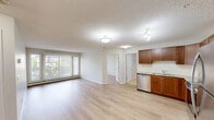 Located at 30 Nevada Pl in St. Albert, Alberta, this well-designed 2-bedroom, 1-bathroom unit offers a comfortable and functional single-floor layout. Light-toned laminate flooring flows consistently throughout the main living areas and bedrooms, creating a clean, cohesive aesthetic.

The kitchen is a standout feature, offering warm medium-toned wood cabinetry, granite-look countertops, and a full suite of stainless steel appliances including a refrigerator, electric range, built-in microwave, and dishwasher. It opens conveniently toward the living area, supporting an easy-flowing layout.

The living room is bright and inviting, featuring large windows and a sliding patio door that frames outdoor views and allows generous natural light to fill the space. The primary bedroom is generously sized, complete with a double-door closet, while the second bedroom also features its own closet and a window with outdoor views.

The bathroom is finished with tile flooring, a granite-top wood vanity, a large mirror, and a full tub-shower combination. A dedicated laundry room houses a stacked washer and dryer unit, adding practical convenience. Textured ceilings are present throughout, and baseboard heating runs along the exterior walls of the main living spaces and bedrooms.