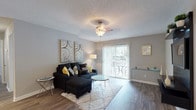 Located at 991 Wylie Rd in Marietta, Georgia, this single-story residence offers a well-designed layout with a cohesive neutral palette and thoughtful finishes throughout. The living room serves as the heart of the home, featuring wood-look plank flooring, a ceiling fan, textured ceiling, and a sliding glass door that opens to a private balcony, allowing an abundance of natural light to fill the space. The kitchen is efficiently designed with white cabinetry, stainless steel appliances including a range, microwave, and refrigerator, complemented by a dark subway tile backsplash and wood-look flooring that flows seamlessly through the common areas. The bedrooms are carpeted for comfort and feature large windows that invite natural light and outdoor views. The primary bedroom includes a walk-in closet and direct access to a full bathroom. Additional bedrooms offer ample space with generous window placement. The bathroom is clean and functional, featuring a tub-shower combination, wood-look tile flooring, a wide vanity with mirror, and bright overhead lighting. Overall, the space presents a modern yet comfortable atmosphere suited for everyday living.