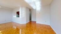 This single-floor, one-bedroom, one-bathroom residence offers a thoughtfully organized layout across a comfortable footprint. The open-concept living and dining area is a standout feature, bathed in abundant natural light streaming through large windows and a sliding glass door that opens onto a private balcony with views of the surrounding urban skyline. The warm-toned parquet flooring runs throughout the main living areas and bedroom, adding classic character to the space.

The kitchen is separated from the living area by a partial wall with a pass-through opening, creating a connected yet defined cooking space. It features rich wood cabinetry, granite-style countertops, a double sink, and white appliances, including a full-size refrigerator and stove, all set on light tile flooring.

The bedroom is a well-proportioned retreat with its own window allowing natural light in, continued parquet flooring, and a double-door closet offering ample storage. The hallways connecting the rooms provide a smooth flow throughout the unit.

The bathroom is finished in clean white tile, featuring a full soaking bathtub with chrome fixtures and tile surround, conveying a simple, functional aesthetic. Overall, the space presents a bright, neutral palette with consistent finishes throughout.