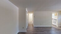 Located at 1114 Tace Dr in Essex, Maryland, this two-bedroom, one-bathroom single-story home offers a practical and well-maintained living environment with a clean, neutral aesthetic throughout. Wood-look flooring runs consistently across all rooms, providing a cohesive and easy-to-maintain foundation that ties the space together.

The living room is bright and open, with natural light filtering in through a window fitted with blinds, creating a welcoming atmosphere. The kitchen is efficiently laid out and features warm honey-toned wood cabinetry, a full suite of white appliances including a gas range, dishwasher, and refrigerator, along with a skylight that adds additional brightness to the space.

The spacious primary bedroom offers generous closet storage with two side-by-side closets, providing ample organization options. The second bedroom is a comfortable size with its own window allowing natural light in. Both bedrooms share neutral wall tones that complement the flooring throughout.

The bathroom is clean and well-appointed, featuring white subway tile wainscoting, a full tub-shower combination with chrome fixtures, and a classic, functional design. The overall interior maintains a consistent, understated color palette of warm whites and beiges, creating a calm and versatile living environment throughout.
