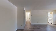 Located at 1114 Tace Dr in Essex, Maryland, this two-bedroom, one-bathroom single-story home offers a practical and well-maintained living environment with a clean, neutral aesthetic throughout. Wood-look flooring runs consistently across all rooms, providing a cohesive and easy-to-maintain foundation that ties the space together.

The living room is bright and open, with natural light filtering in through a window fitted with blinds, creating a welcoming atmosphere. The kitchen is efficiently laid out and features warm honey-toned wood cabinetry, a full suite of white appliances including a gas range, dishwasher, and refrigerator, along with a skylight that adds additional brightness to the space.

The spacious primary bedroom offers generous closet storage with two side-by-side closets, providing ample organization options. The second bedroom is a comfortable size with its own window allowing natural light in. Both bedrooms share neutral wall tones that complement the flooring throughout.

The bathroom is clean and well-appointed, featuring white subway tile wainscoting, a full tub-shower combination with chrome fixtures, and a classic, functional design. The overall interior maintains a consistent, understated color palette of warm whites and beiges, creating a calm and versatile living environment throughout.