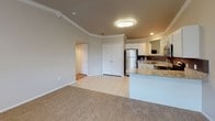 This single-floor home offers a thoughtfully designed layout that balances comfort and functionality throughout. The kitchen serves as a standout feature, showcasing crisp white cabinetry, granite countertops with subtle veining, a tile backsplash, and a full suite of stainless steel appliances including a range, microwave, and dishwasher. Light tile flooring and recessed lighting complete the kitchen's clean, modern aesthetic. Crown molding accents the kitchen and living areas, adding a refined architectural touch throughout the space.

The living area is generously proportioned, with plush carpeting underfoot, crown molding along the ceiling, a ceiling fan with light fixture, and a window that invites natural light into the room. The open sightlines between the kitchen and living space create an easy, connected flow ideal for everyday living.

The bedrooms are comfortably sized, each featuring soft carpet, neutral walls, ceiling fans, and closet access, providing a calm and practical retreat. Additional rooms offer flexible space with the same warm, neutral palette.

The bathroom is efficiently appointed with a tub-shower combination, white cabinetry with overhead storage, a vanity with a framed mirror, and tile flooring, delivering a tidy and functional design. Overall, the home presents a clean, move-in ready environment with consistent finishes throughout.