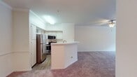 This 750 square foot apartment offers a thoughtful design that maximizes space and functionality. The modern kitchen is a highlight, featuring white cabinetry, stainless steel appliances, and a convenient breakfast bar that opens to the living area. The spacious bedroom, measuring 140 square feet, boasts plush carpeting and a large window that allows natural light to flood the space. A ceiling fan adds both style and comfort.

The full bathroom is well-appointed with a bathtub-shower combination, toilet, and vanity. Wood-look flooring in the bathroom adds warmth and durability. The apartment includes an in-unit laundry area with a washer and dryer, enhancing convenience for residents.

Throughout the apartment, neutral tones dominate, creating a clean and versatile canvas for personal decor. Crown molding adds a touch of elegance to the living spaces. The layout is efficient, with a hallway connecting the various rooms and providing easy flow throughout the home.

Storage solutions are plentiful, with a dedicated closet space and additional storage in the kitchen and bathroom. The overall design prioritizes functionality without sacrificing style, making this apartment an ideal choice for those seeking a compact yet comfortable living space.