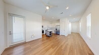 Located at 515 Corso Ln in Davenport, Florida, this two-story, two-bedroom, two-bathroom home offers a clean, modern design with thoughtful layout across two levels. The ground floor hosts the main living areas, including an open-concept living and kitchen space bathed in natural light from multiple windows dressed with white blinds. The kitchen is well-appointed with white shaker cabinetry, grey quartz countertops, a subway tile backsplash, stainless steel appliances including a French door refrigerator and dishwasher, and a movable island for added flexibility. Warm hardwood-style flooring flows throughout the main level, complemented by recessed lighting and a ceiling fan overhead. The attached garage provides secure parking and additional storage space. Upstairs, the more spacious upper floor houses both bedrooms, each featuring ceiling fans and plush carpeting. The generously sized primary bedroom includes a walk-in closet outfitted with wire shelving. The bathrooms are finished with classic subway tile surrounds, soaking tubs, and hardwood-style flooring. A dedicated laundry room with a full-size washer and dryer adds everyday convenience, completing this well-equipped and efficiently designed home.