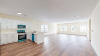 Located at 435 Morris Ave in Elizabeth, NJ, this well-appointed 2-bedroom, 2-bathroom home offers generous living space thoughtfully arranged on a single floor. The open-concept kitchen and living area serves as the heart of the home, featuring warm hardwood-style flooring, recessed lighting, and large windows that allow abundant natural light to fill the space. The kitchen is outfitted with crisp white shaker cabinetry, light countertops, a peninsula with seating potential, and stainless steel appliances including a gas range, over-the-range microwave, and full-size refrigerator. The spacious living room offers a bright, airy feel with multiple windows framing outdoor views. The generously sized primary bedroom includes double closet doors and natural light, while an additional walk-in closet with built-in shelving and hanging rods provides excellent storage. Both bathrooms feature light tile flooring, a wall-mounted vanity, and a shower-tub combination. A dedicated laundry room houses a full-size washer and dryer. Throughout the home, warm neutral walls and consistent hardwood-style flooring create a cohesive, clean aesthetic that is both modern and inviting.