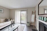 Located at 3400 W Park Blvd in Plano, TX, this well-appointed one-bedroom, one-bathroom home offers a thoughtfully designed single-floor layout. The living room serves as the heart of the space, featuring wood-style flooring, a textured ceiling, and a sliding glass door fitted with vertical blinds that opens to an outdoor patio, allowing natural light to pour in. A fireplace adds a charming focal point to the room. The adjacent dining area is brightened by a window with horizontal blinds and is accented by an elegant chandelier overhead. From the dining room, a hallway leads directly into the kitchen, which is equipped with white cabinetry, granite-look countertops, a stainless steel refrigerator and appliances, and a stylish mosaic tile backsplash. A dedicated laundry area and multiple closets provide excellent storage throughout. The bedroom is a comfortable retreat featuring wood-style flooring, a ceiling fan, natural window light, and a walk-in closet. The bathroom offers a full tub-shower combination with floor-to-ceiling gray tile surround, a mosaic accent strip, a white vanity with granite-look countertop, and wood-style flooring. Neutral tones and consistent finishes create a cohesive, move-in-ready atmosphere throughout the home.