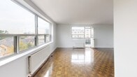 Located on the sixth floor at 2220 Weston Road in Toronto, this well-appointed one-bedroom, one-bathroom unit offers a comfortable and functional layout across a single floor. Rich parquet hardwood flooring flows throughout the living spaces, adding warmth and character to the clean, white-walled interior.

The spacious living room is filled with natural light from large windows that frame open city views, with a door leading directly to a private balcony. The balcony features a glass railing, extending the living space outdoors and providing a pleasant elevated perspective of the surrounding neighbourhood.

The generously sized primary bedroom includes a wide window with a radiator beneath it, allowing for natural light and comfortable year-round temperature control. Its proportions make it a notably versatile space.

The kitchen is equipped with stainless steel appliances, including an electric range and over-the-range microwave, complemented by sleek countertops, white cabinetry, and a light-toned subway tile backsplash. Dark floor tiles complete the kitchen's contemporary aesthetic.

The bathroom is finished with classic white subway tile surrounding the bathtub, paired with a quartz-topped vanity, creating a clean and timeless look. Two hallways provide practical connectivity throughout the unit, ensuring a smooth and organized flow between all rooms.