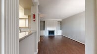 Located at 15100 Ella Blvd in Houston, TX, this single-story, three-bedroom, three-bathroom home offers a functional and comfortable layout. The living room serves as the heart of the home, featuring rich hardwood-style flooring, crown molding, a tile-surround fireplace with a classic white mantle, and built-in shelving — creating a warm and inviting atmosphere. The kitchen is equipped with ample cabinetry featuring light wood accents, granite-style countertops, and white appliances, providing a practical workspace. Each of the three bedrooms is carpeted and includes its own dedicated closet; the primary bedroom is notably spacious and is served by a walk-in closet fitted with wire shelving on multiple walls. The bathrooms are consistent in style, featuring tile-surround tub-shower combinations with chrome fixtures, vanities with granite-style countertops, and wood-style flooring. A dedicated laundry room includes washer and dryer hookups along with overhead wire shelving for additional storage. Two hallways connect the various areas of the home efficiently. The attached garage provides direct interior access and overhead door operation. Overall, the home presents a clean, neutral palette throughout, offering a solid foundation for personalization.