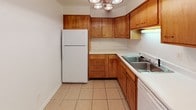 Located at 144 Bellaire St in Dayton, Ohio, this single-floor residence offers a well-organized layout with a variety of functional living spaces. The kitchen is outfitted with warm-toned wood cabinetry offering ample storage through both upper and lower cabinets and built-in drawers. Light-colored countertops complement the neutral tile flooring, while a double-basin sink and included appliances add practical convenience. An overhead multi-bulb light fixture brightens the space effectively. The bathroom features a retro aesthetic with light blue wall tiles extending from floor to mid-wall, a matching tub and sink, and a wood-toned vanity beneath a large mirrored medicine cabinet — lending it a distinctive, vintage character. The living area is generously proportioned, finished with neutral carpet throughout, and opens directly to a private balcony through sliding glass doors, allowing natural light to flow into the space. A ceiling fan adds comfort to the main living area. The bedrooms are carpeted and bright, with windows offering views of surrounding greenery. One bedroom includes a walk-in closet with built-in shelving, providing excellent storage. The overall layout, as seen in the dollhouse view, is open and efficiently designed, offering a comfortable and livable single-level floor plan.