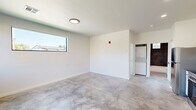 Located at 1540 NW 30th St in Oklahoma City, Oklahoma, this efficiently designed one-bedroom, one-bathroom unit offers a clean, modern aesthetic across a single floor. Polished concrete floors run throughout the entire space, lending an industrial-contemporary character that ties each room together cohesively.

The open kitchen is outfitted with white shaker cabinetry, dark countertops, and a full suite of stainless steel appliances including a refrigerator, range, over-the-range microwave, and dishwasher. Recessed lighting above ensures the kitchen is well-lit and functional.

The living area features crisp white walls and large horizontal windows that allow natural light to fill the room, with views of the surrounding neighborhood. A stacked washer and dryer unit is conveniently tucked into a dedicated nook, adding in-unit laundry functionality.

The bedroom is a well-proportioned private retreat with a ceiling fan, a large window offering neighborhood views, and clean white walls that create a bright, airy feel.

The bathroom is a standout space, showcasing floor-to-ceiling dark charcoal tile in the tub/shower surround, a white vanity with modern black hardware, polished concrete flooring, and a small window above the tub for natural light. The contrast between the dark tile and white fixtures creates a striking, upscale look.