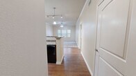 This thoughtfully designed single-story residence offers a comfortable and functional layout across a single floor. The open-concept kitchen and living area serves as the heart of the home, featuring warm hardwood-style flooring, crown molding, and a ceiling fan. The kitchen is equipped with rich, dark wood cabinetry, granite-style countertops, a breakfast bar peninsula with pendant lighting, black appliances including a refrigerator, electric range, microwave, and dishwasher, plus a double-basin sink. A dedicated pantry provides additional storage.

The living area extends naturally from the kitchen, offering plush carpeting, a ceiling fan, built-in shelving, and direct access to the outdoors via a glass-paneled door flanked by windows that invite natural light.

The spacious bedroom features soft carpet flooring, two windows with blinds, and generous closet space supported by two separate closets, including a walk-in with built-in rods. The full bathroom offers a wide vanity with granite-style countertops and dark wood cabinetry, tile flooring, and a full soaking tub. A dedicated laundry area and a pantry round out the practical amenities of this well-organized residence.