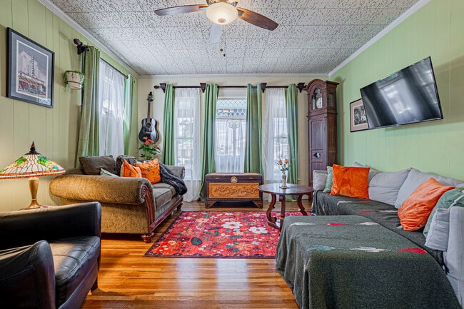 Cozy Victorian-style living room with comfy seating and a Roku TV—ideal for relaxing or entertaining - 337 W 16th St