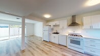 Located at 39869 Fremont Blvd in Fremont, California, this two-story home showcases a clean, modern aesthetic with fresh updates throughout. Light wood-style flooring runs consistently across both levels, creating a cohesive and inviting atmosphere.

The kitchen is a standout feature, outfitted with white shaker-style cabinetry offering ample storage, white quartz countertops, a stainless steel range hood, a gas range, dishwasher, and a refrigerator. A black undermount sink adds a contemporary contrast to the bright, airy design.

The open living area benefits from abundant natural light, enhanced by sliding glass doors that lead to an outdoor space, seamlessly connecting the interior to the exterior. The layout flows naturally from the living area into the kitchen.

The bedrooms are generously proportioned, with one featuring a vibrant teal accent wall and large windows that draw in natural light. Another bedroom is finished in warm neutral tones with a louvered closet door and sun-drenched hardwood floors.

The bathrooms are thoughtfully designed with white vanities, modern matte black hardware, and wood-look flooring. One bathroom features a frameless glass walk-in shower with a rain showerhead, while another offers a bright window and clean, minimalist finishes throughout.

A central staircase connects both floors, completing this well-appointed and move-in-ready home.