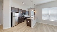 Located along St. Peters Centre Blvd in St. Peters, Missouri, this single-floor residence offers a well-designed layout with modern finishes throughout. The open-concept living area features light wood-style flooring, a ceiling fan, and generous natural light streaming through multiple windows with blinds, creating a bright and airy atmosphere.

The kitchen is a standout feature, outfitted with rich dark cabinetry, granite countertops, a subway tile backsplash, stainless steel appliances including a refrigerator, range, microwave, and dishwasher, along with pendant lighting above a center island with a built-in sink. A corridor-style kitchen layout maximizes counter and storage space efficiently.

The bedrooms are carpeted for comfort, with one bedroom featuring a large window that invites ample natural light and a ceiling fan. A spacious walk-in closet with wire shelving on multiple walls provides generous storage capacity. The hallways connect the spaces seamlessly, with light flooring continuing throughout the common areas.

Both bathrooms are finished with dark wood vanities, granite countertops, undermount sinks, and large mirrors. The primary bathroom includes additional storage, while a second full bathroom offers a clean, functional design. The overall aesthetic is clean and contemporary, consistent throughout the entire residence.