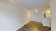 Located at 10 Primrose in Haverhill, Massachusetts, this single-floor residence offers a well-maintained and thoughtfully finished living space. The interior is characterized by a clean, neutral color palette with crisp white walls and ceilings that create a bright and airy atmosphere throughout. Rich hardwood-style flooring runs throughout the space, providing warmth and a sense of continuity from room to room. Crown molding accents the ceilings, adding a refined architectural detail that elevates the overall aesthetic. The main living area is open and spacious, with recessed track lighting that ensures even, functional illumination across the room. Classic white baseboards and chair rail molding further contribute to the polished, well-appointed feel of the interior. The layout flows naturally, making the space feel welcoming and versatile. Overall, this residence at 10 Primrose combines timeless design elements with practical finishes, resulting in a comfortable and move-in-ready home suited for a variety of living arrangements.