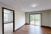 This two-bedroom, two-bathroom unit at 1600 Kitty Hawk Drive in Columbia, Missouri offers a well-organized single-floor layout with a thoughtful mix of materials and functional design throughout. The open living area features warm hardwood-style flooring and neutral walls, creating a bright and versatile space. Dark-trimmed panel doors add a refined contrast against the light interior palette.

The galley-style kitchen is efficiently designed with ample warm-toned wood cabinetry, granite-look countertops, and a full suite of black appliances including an electric range with over-the-range microwave, refrigerator, and dishwasher. A skylight provides additional natural illumination, making the kitchen feel open and practical.

Both bedrooms are carpeted for comfort and include ceiling fans, natural light from large windows with blinds, and sliding panel closet doors. The spacious primary bedroom offers a generous footprint with peaceful outdoor views.

The bathrooms are clean and functional, featuring a tub-shower combo with built-in shelving and brushed nickel fixtures. A dedicated laundry room includes shelving, dryer venting, and an electrical panel for added convenience. The unit also includes access to a private balcony overlooking mature trees and the surrounding neighborhood.