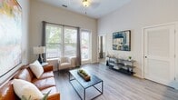 Located at 4201 Runner Loop in Chester, Virginia, this single-floor residence showcases a thoughtfully designed open-concept layout with modern finishes throughout. The living area is bright and welcoming, featuring wood-style flooring, tall ceilings, and large windows that frame views of the surrounding greenery, allowing generous natural light to fill the space. A glass-paneled door provides additional connectivity to the outdoors.

The kitchen is a standout feature, equipped with stainless steel appliances including a refrigerator, range, microwave, and dishwasher. Light wood-toned cabinetry pairs elegantly with dark granite countertops, and a peninsula with bar seating serves as both a functional workspace and a casual dining area. Pendant lighting overhead adds a polished finishing touch.

The primary bedroom is a serene retreat with plush carpeting, a window with outdoor views, and direct access to a private bathroom. The en-suite bath includes granite countertops, wood-style flooring, and a walk-in closet with built-in shelving. A second bedroom is equally well-appointed, with carpeted flooring and natural light from dual windows. A second full bathroom features a vanity with granite countertops and a shower-tub combination, maintaining the home's consistent, contemporary aesthetic.