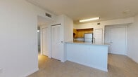 Located in Miami, FL, this single-floor, 2-bedroom, 2-bathroom residence offers a practical and well-organized layout. The open-concept kitchen serves as the heart of the home, featuring light wood cabinetry, stainless steel appliances including a refrigerator and electric range, a double-basin sink, and speckled granite-style countertops that extend to a peninsula island — ideal for casual dining or meal prep. The kitchen flows naturally into the combined dining and living area, which benefits from a ceiling fan and a window that brings in natural light.

The hallway connects the living spaces to the bedrooms and bathrooms, aided by ample closet storage — six closets in total — along with a dedicated pantry and in-unit laundry. The primary bedroom offers a comfortable footprint with ceiling fan and natural light. The secondary bedroom features corner windows that frame views of the surrounding Miami neighborhood and palm-lined streetscapes, filling the room with abundant daylight.

Both bathrooms are finished consistently with speckled countertop vanities and wood cabinetry, with one bathroom featuring a full tub-shower combination with white tile surround. Light tile flooring runs throughout the unit, creating a clean, cohesive aesthetic well-suited to the Miami climate.