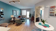 This single-floor residence showcases a contemporary design highlighted by striking teal accent walls that create a vibrant, cohesive aesthetic throughout. The open-concept living and dining area is bathed in natural light from large windows and a glass patio door, which also provides access to an outdoor balcony. Hardwood-style flooring runs throughout the main living spaces, adding warmth and continuity to the layout.

The kitchen is a standout feature, boasting dark espresso cabinetry, a tiled backsplash, stainless steel appliances including a gas range, microwave, and refrigerator, and a generous quartz-topped island with an undermount sink and pendant lighting overhead — ideal for both meal preparation and casual dining.

The bedrooms continue the teal accent wall motif, offering plush carpeting, ample natural light through windows dressed with patterned curtains and blinds, and enough space to comfortably accommodate large furniture arrangements.

The bathroom is clean and functional, featuring dark cabinetry with a white countertop vanity, a large mirror, and coordinating teal accents. Hardwood-style flooring extends into this space as well, maintaining design consistency.

Overall, the residence presents a well-curated, modern living environment with a bold yet balanced color palette, quality finishes, and a comfortable, functional flow between spaces.
