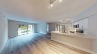 Located at 500 North Congress Avenue in Delray Beach, Florida, this 2-bedroom, 2-bathroom residence offers a well-designed single-floor layout that maximizes functionality and comfort. Light wood-tone flooring flows consistently throughout the unit, complemented by neutral gray-white walls and crisp white baseboards that create a clean, modern aesthetic.

The open-concept living and dining area is bright and spacious, anchored by a large sliding glass door that invites natural light and provides views of the surrounding greenery. Track lighting overhead enhances the airy feel of the shared living space.

The kitchen is outfitted with stainless steel appliances, including a refrigerator, electric range, and built-in microwave. Two-tone cabinetry — white upper cabinets with wood-finish lower cabinets — pairs with light quartz countertops and a peninsula that serves as a natural divider between the kitchen and living area.

Both bedrooms are comfortably sized with natural light from windows and continue the same light flooring found throughout. The spacious primary bedroom provides ample room for furnishings. A dedicated closet adds convenient storage.

Both bathrooms feature a tub/shower combination, light quartz vanity countertops, and wood-finish cabinetry, maintaining the consistent modern design language of the home. A textured ceiling is present throughout the residence.