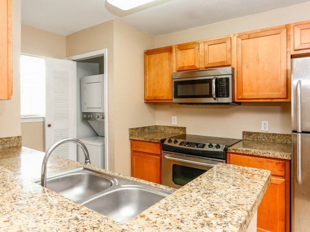 Modern kitchen with in-unit laundry access - The Village at Melbourne
