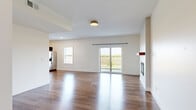 This single-story home on E Courtland Street in Morton, Illinois, presents a clean, modern design throughout its well-organized layout. The main living area is expansive and open, finished with rich, dark hardwood flooring that reflects natural light streaming in through multiple windows and a sliding glass door. The glass door provides direct views of the surrounding landscape, enhancing the sense of openness. A built-in electric fireplace with a warm wood mantel shelf serves as a focal point along one wall, adding both style and function to the living space.

The kitchen is outfitted with dark espresso cabinetry, white quartz-style countertops, and a classic white subway tile backsplash. Stainless steel appliances, including a range, microwave, and dishwasher, complete the functional workspace. A window above the sink provides natural light to the area.

The bedrooms feature soft, neutral carpeting and windows fitted with blinds, offering comfortable, well-lit spaces. The bathroom includes a dark-cabinet vanity with a white countertop and a large mirror, connecting conveniently to an adjoining carpeted room. Throughout the home, white walls, recessed lighting, and consistent finishes contribute to a cohesive, contemporary aesthetic.