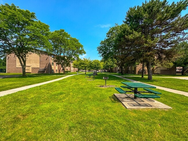 Expansive green space with picnic area at Woodland Villa Apartments in Westland, MI. - Woodland Villa Apartments