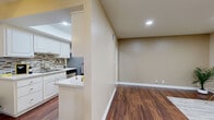 Located at 861 Glencliff St in La Habra, California, this one-bedroom, two-bathroom home offers a thoughtfully arranged single-level floor plan that makes efficient use of its space. Rich, dark hardwood-style flooring flows throughout the main living areas, creating a warm and cohesive aesthetic.

The living room is bright and welcoming, featuring recessed lighting and a large window with vertical blinds that invite natural light. It connects seamlessly to the kitchen via a half-wall partition, lending an open, airy feel. The kitchen is well-appointed with crisp white cabinetry, a mosaic tile backsplash, light countertops, and a full suite of stainless steel appliances including a refrigerator, dishwasher, gas range, and microwave. A ceiling fan with light fixture adds comfort to the adjacent dining area.

The generously sized bedroom is carpeted for comfort and features a mirrored sliding-door closet with built-in shelving, along with windows offering views of the surrounding neighborhood. The two bathrooms are clean and functional, with one featuring a grab bar and a frosted glass window for natural light and privacy.

A connecting hallway ties the layout together efficiently. Neutral warm tones throughout create a calm, inviting ambiance well-suited to everyday living in sunny Southern California.