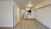 This two-floor residence offers a well-designed layout that balances functionality and comfort across both levels. The main living area features smooth wood-look flooring that flows seamlessly into the open-concept kitchen, where dark espresso cabinetry contrasts elegantly with light granite-style countertops. The kitchen is equipped with stainless steel appliances, including a range, over-the-range microwave, and refrigerator, and features a breakfast bar with seating — ideal for casual dining. A hallway connects the living space to additional rooms, with clean white walls throughout that contribute to a bright, airy ambiance. One of the living areas on the upper level includes a sliding glass door with vertical blinds, offering access to an outdoor area and bringing in generous natural light. The bedrooms are finished with plush carpeting, providing a warm and comfortable retreat. The bathrooms are appointed with dark vanity cabinetry, granite-style countertops, and tile flooring. One bathroom features a shower with curtain, while another offers a full soaking tub and shower combination. A staircase connects the two floors, and the overall layout provides a practical flow throughout the home.