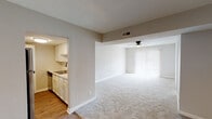 This single-story, two-bedroom, one-bathroom residence offers a practical and comfortable layout across a well-utilized footprint. The open-concept living and dining area serves as the heart of the home, finished with plush wall-to-wall carpeting and a ceiling fan overhead. A large sliding glass door dressed with vertical blinds anchors the living space, allowing abundant natural light to pour in and providing outdoor access.

The kitchen is positioned adjacent to the living area and separated by a partial wall, creating a semi-open connection between the two spaces. It features stainless steel appliances, including an electric range with a ventilation hood and a refrigerator, paired with white cabinetry featuring gold-toned hardware, a tiled backsplash, and hardwood-style flooring that contrasts with the carpeted living areas.

Both bedrooms are carpeted and include ceiling fans with light fixtures and windows fitted with blinds for natural light and privacy. The full bathroom is equipped with a tub-shower combination, a toilet, and hardwood-style flooring. Textured walls are consistent throughout the residence, contributing to a cohesive interior character. The layout is straightforward and efficiently designed for comfortable everyday living.