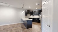 Located at 2100 W Littleton Blvd in Littleton, CO, this well-designed one-bedroom, one-bathroom residence offers a thoughtful layout across a single floor. Warm hardwood-style flooring flows consistently throughout the unit, creating a cohesive and inviting aesthetic.

The open-concept kitchen and living area serves as the heart of the home. The kitchen is outfitted with dark espresso cabinetry, light quartz countertops, a peninsula with seating potential, stainless steel appliances including a gas range and refrigerator, a tile backsplash, and stylish pendant lighting. The adjacent living area is bright and airy, benefiting from a ceiling fan and a private entrance door flanked by windows that allow generous natural light and views of mature trees.

The bedroom is a comfortable, well-proportioned space featuring a ceiling fan, a large window with outdoor views, and access to a dedicated walk-in closet outfitted with built-in shelving and hanging rods for organized storage.

The bathroom is clean and contemporary, highlighted by a glass-enclosed walk-in shower with white subway tile, a decorative mosaic accent border, a built-in niche, and chrome fixtures. Light tile flooring completes the polished look. Neutral wall tones throughout the unit contribute to a calm, modern ambiance.