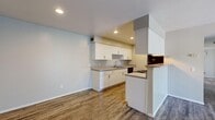 Located in South Salt Lake, Utah, this single-floor unit offers four bedrooms and two full bathrooms within a efficiently designed layout. The open-concept kitchen and living area serves as the heart of the home, featuring wood-look luxury vinyl plank flooring, crisp white shaker cabinetry, gray countertops, a stainless steel sink, and black appliances including a refrigerator and range. Recessed lighting illuminates the kitchen, which flows seamlessly into the living area. The living room benefits from a sliding glass door that invites natural light and provides outdoor access. The four bedrooms are carpeted for comfort, with neutral toned walls and ample natural light from windows fitted with vertical blinds. The primary bedroom includes a dedicated closet with built-in shelving and hanging rods. Additional bedrooms offer sliding-door closets with built-in organizers. Both bathrooms are finished with white vanity cabinetry, gray countertops, wood-look flooring, and tub-shower combinations with tile surrounds. A central hallway connects the bedrooms and bathrooms, providing a practical flow throughout the unit. The overall aesthetic is clean, modern, and move-in ready, with consistent finishes and a neutral palette throughout.
