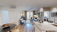This 2-bedroom, 2-bathroom residence combines modern design with functional living across a single, well-organized floor. The open-concept kitchen flows seamlessly into the dining and living areas, anchored by a granite-topped island with bar seating and pendant lighting overhead. Gray shaker-style cabinetry, a subway tile backsplash, and stainless steel appliances complete the kitchen. Light wood-style flooring runs throughout the main living areas, enhancing the bright, airy atmosphere. The living room features a ceiling fan, large windows, and glass doors that lead to a private balcony, filling the space with natural light. The primary bedroom offers plush carpeting, a ceiling fan, ample natural light, and access to an en-suite bathroom with a granite dual vanity, walk-in glass shower, and a walk-in closet. The second bedroom is equally well-sized with carpeting, a ceiling fan, and generous window views. The second bathroom includes a granite vanity and a soaking tub. Additional highlights include two closets, and an in-unit laundry area equipped with a Whirlpool washer/dryer. The residence delivers a clean, contemporary aesthetic throughout with thoughtful attention to detail at every turn.